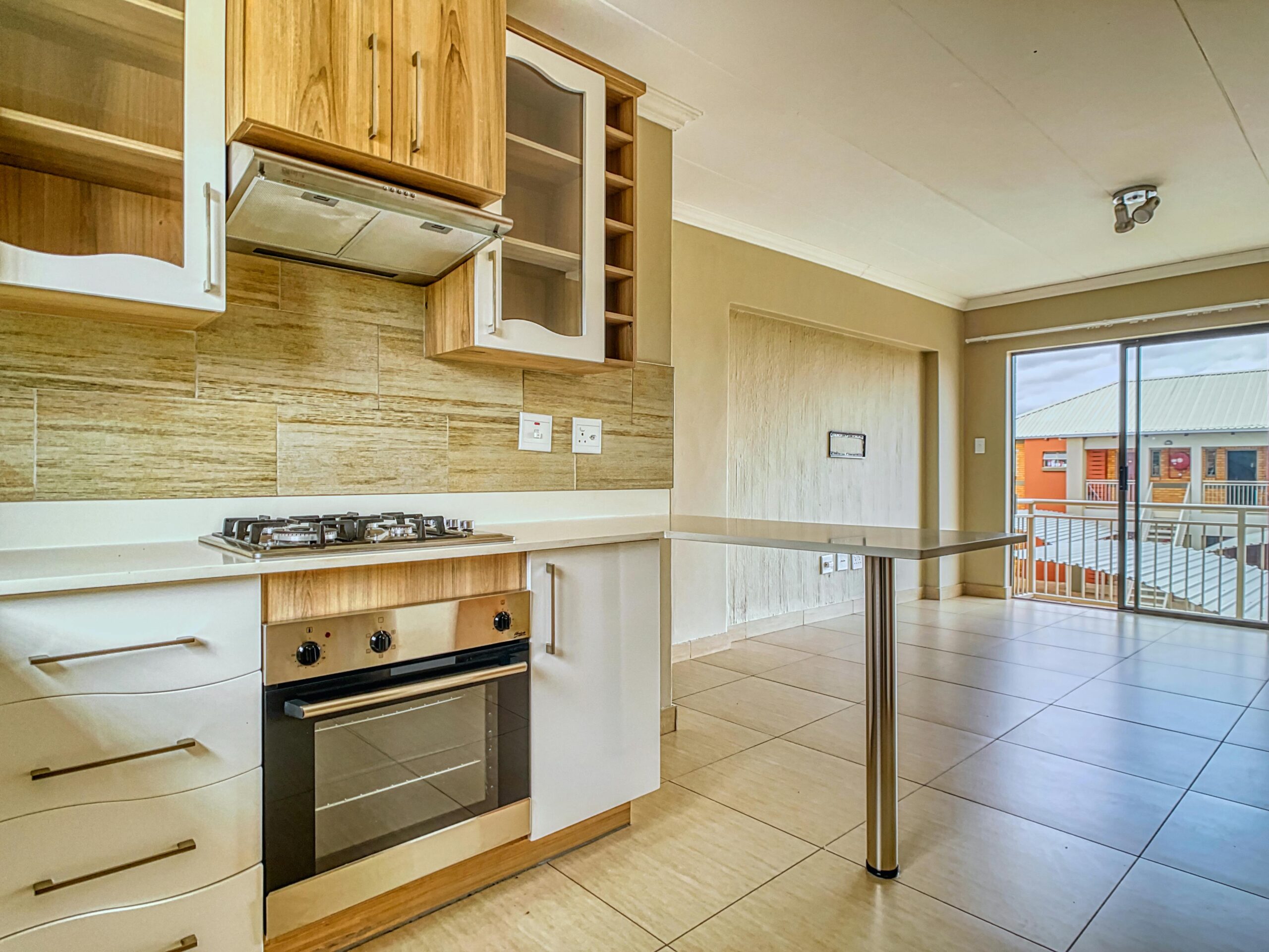 Bright and clean kitchen interior with wood cabinets and a gas stove in a Pretoria residence.